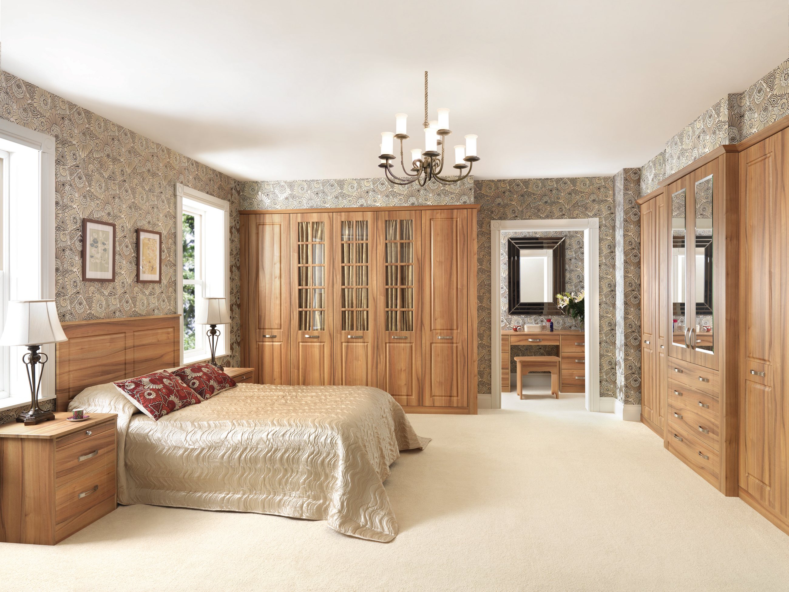 A large oak fitted wardrobe suite with a mirror and dressing area