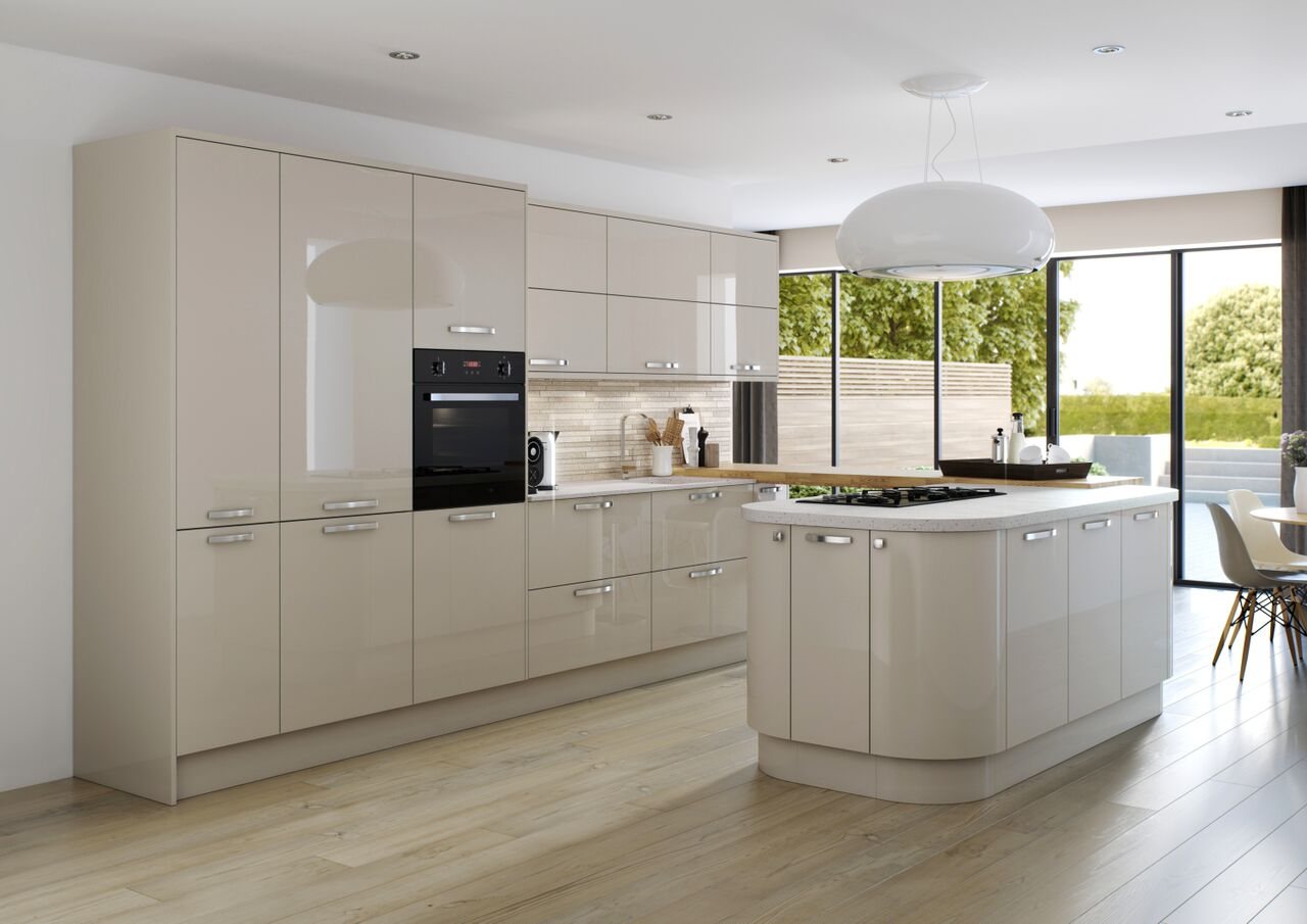 A cream gloss kitchen with a curved island and integrated ovens