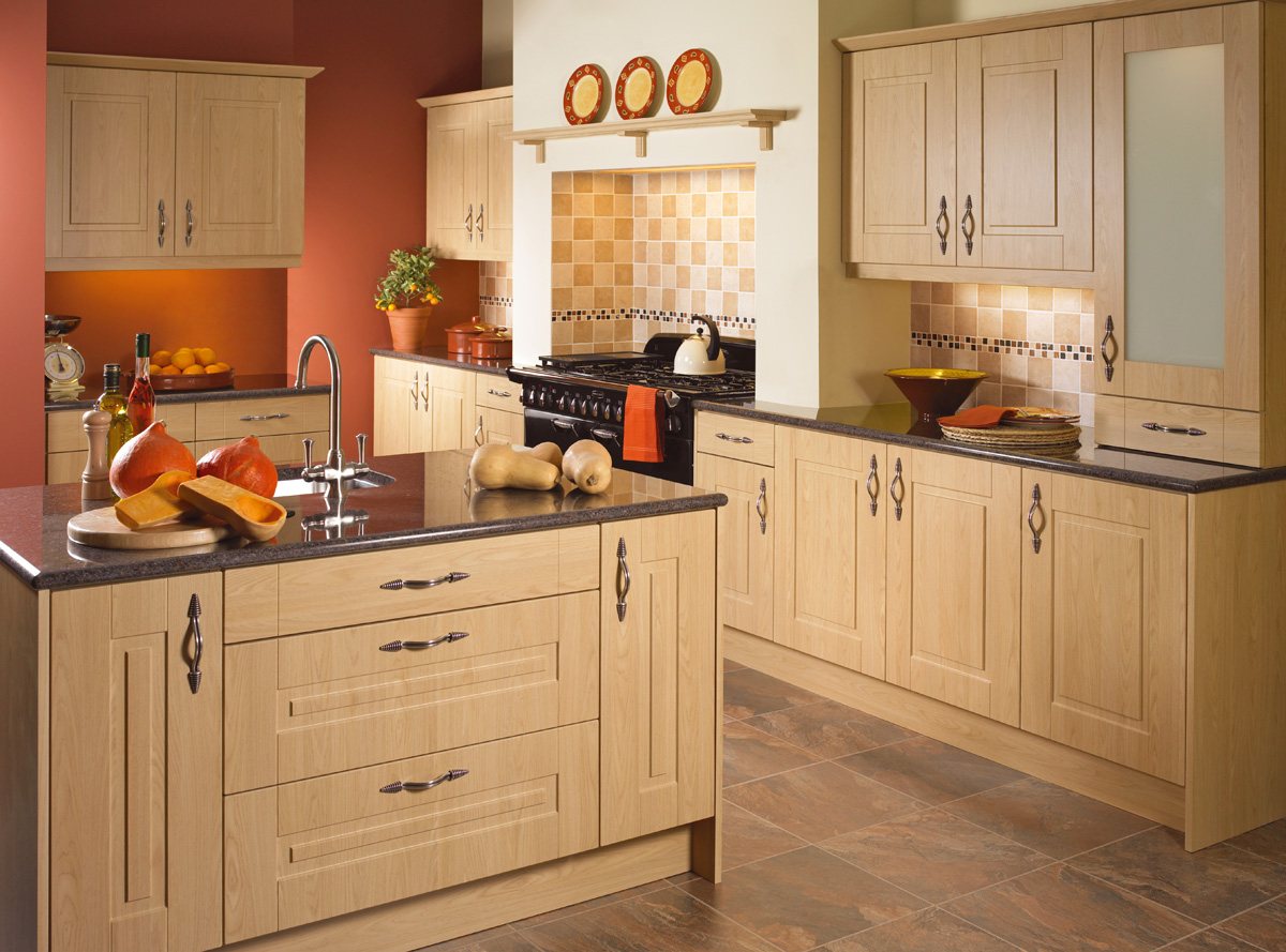 A light oak kitchen with dark worktops and a tiled splashback