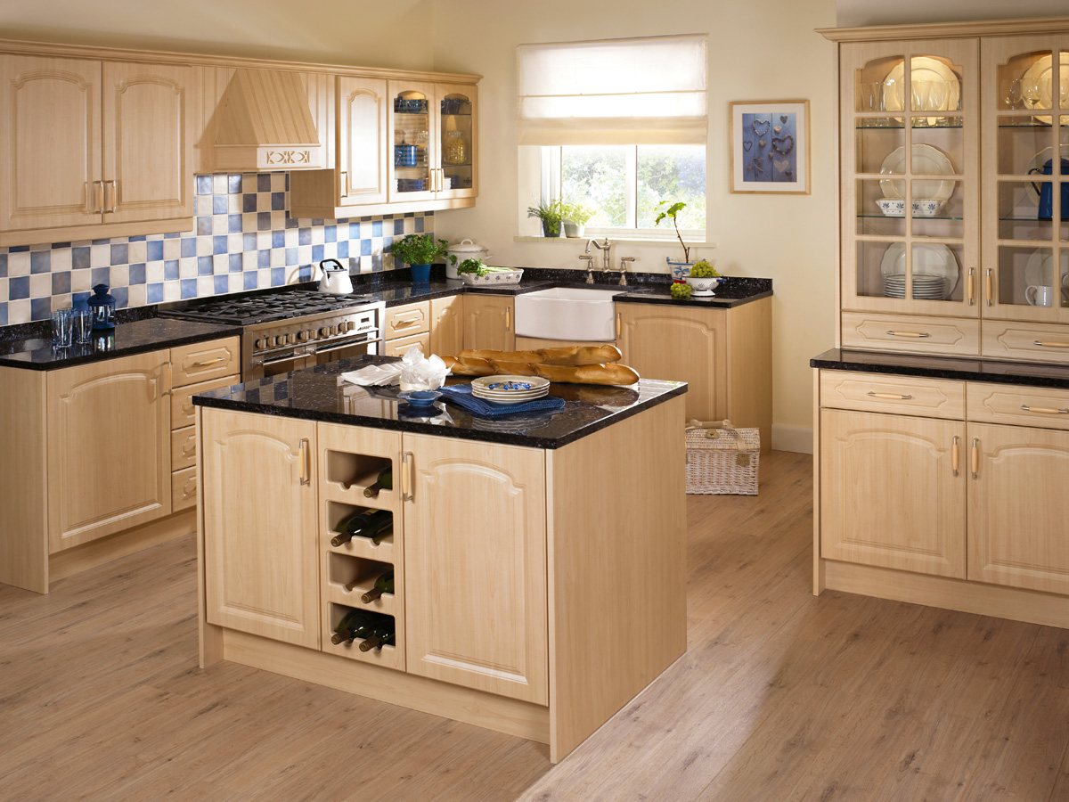 A light oak traditional kitchen with black granite worktops and a range cooker