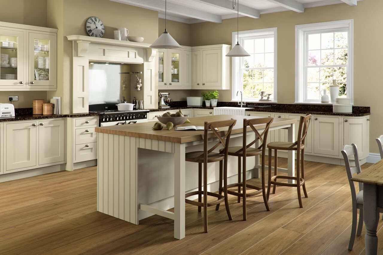 A cream in-frame kitchen with a large timber island and bar stools